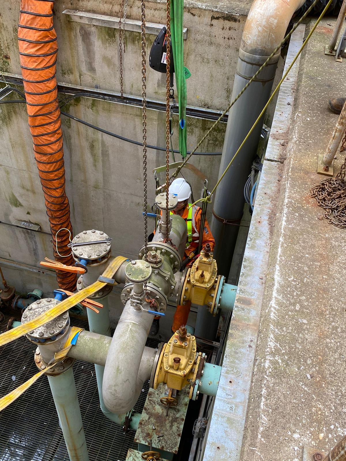 Engineer rigging a valve manifold lift into a plant chamber