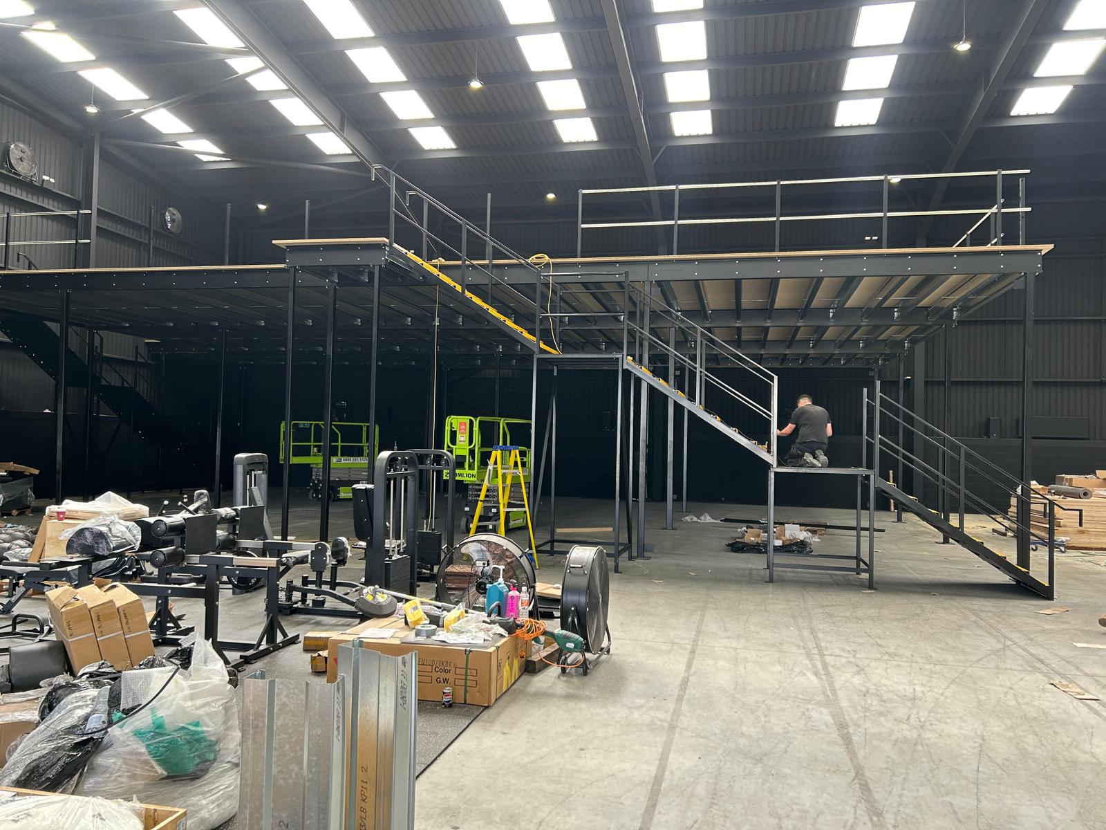 Completed mezzanine platform with handrails and access staircase in warehouse