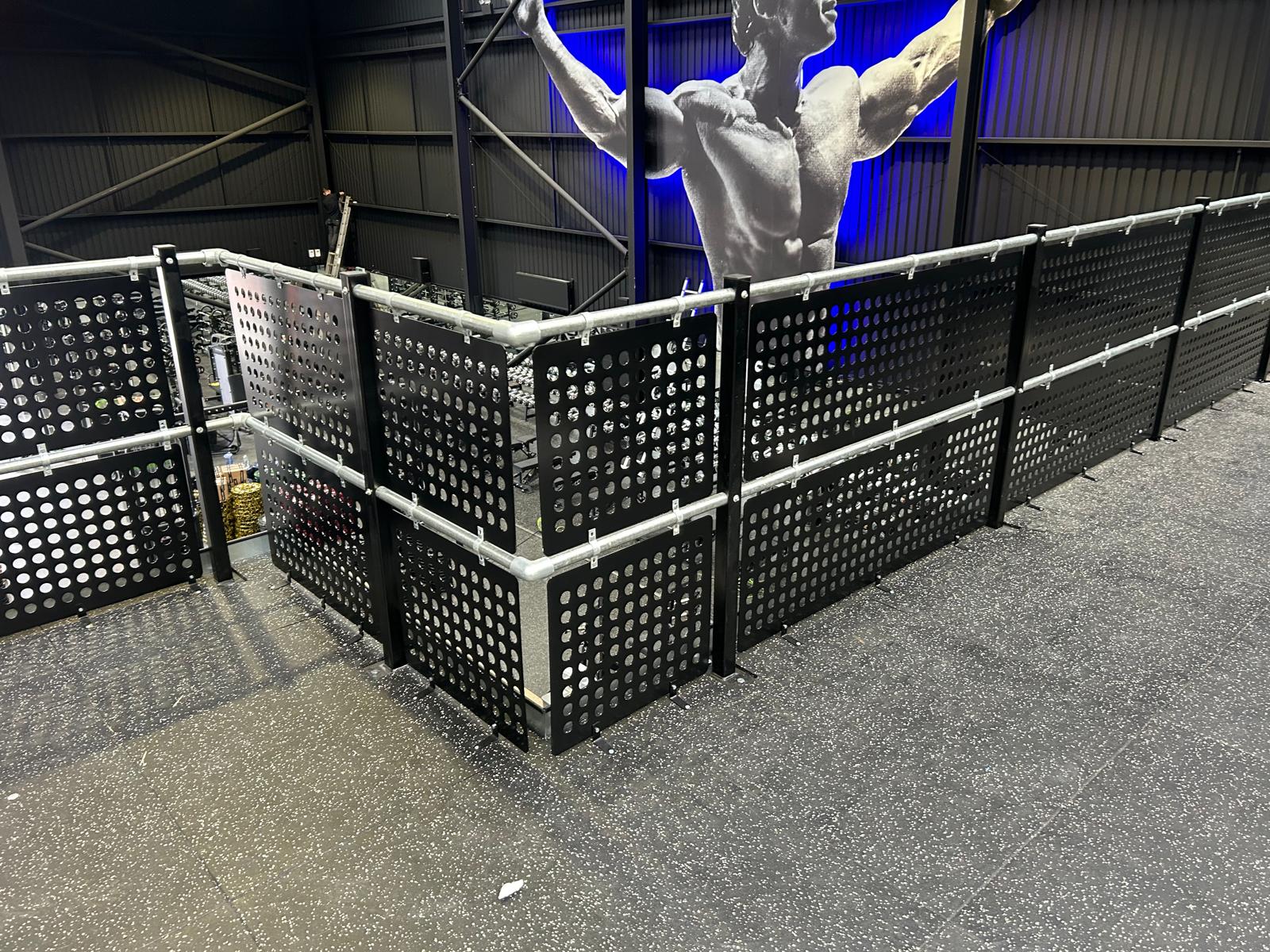 Bespoke fabricated perforated steel screens installed around gym platform